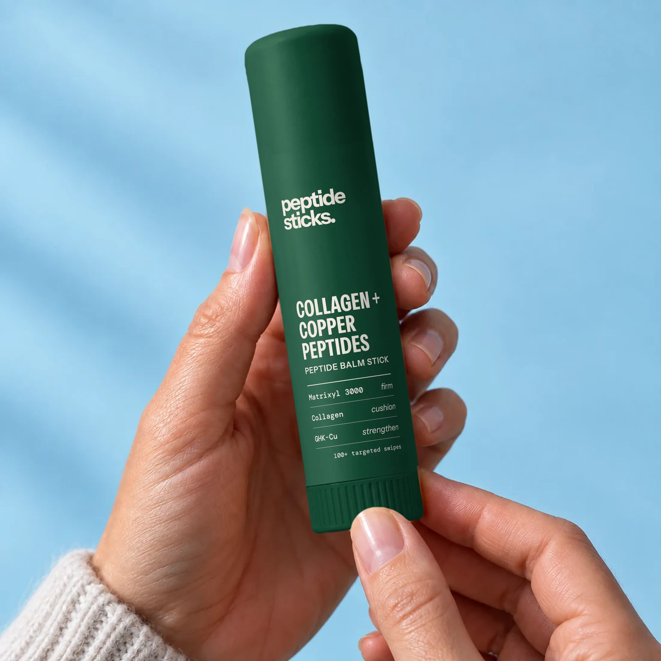 Holding the Collagen + Copper Stick under a blue sky
