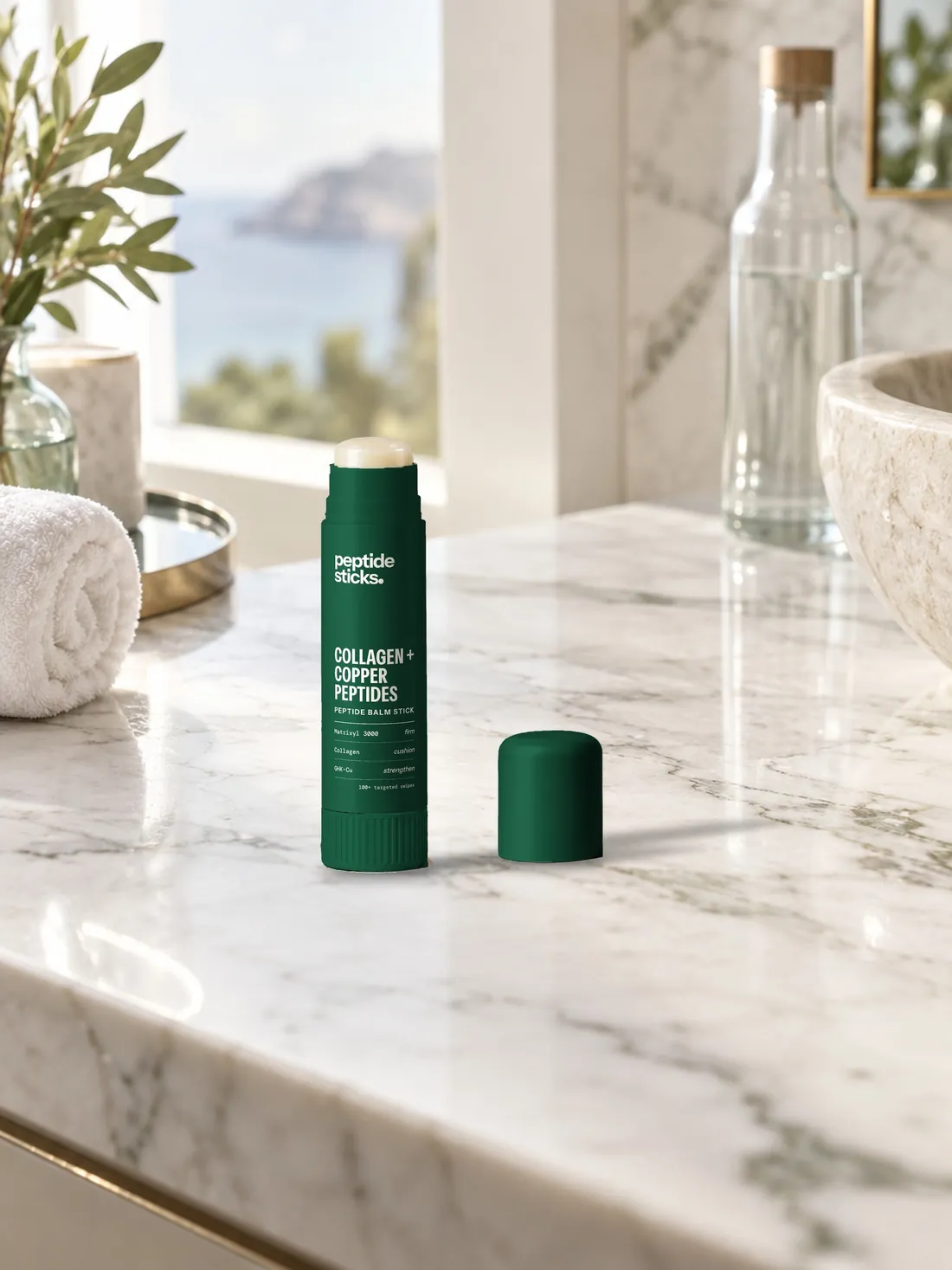 The Collagen + Copper Stick on a marble bathroom counter by a window