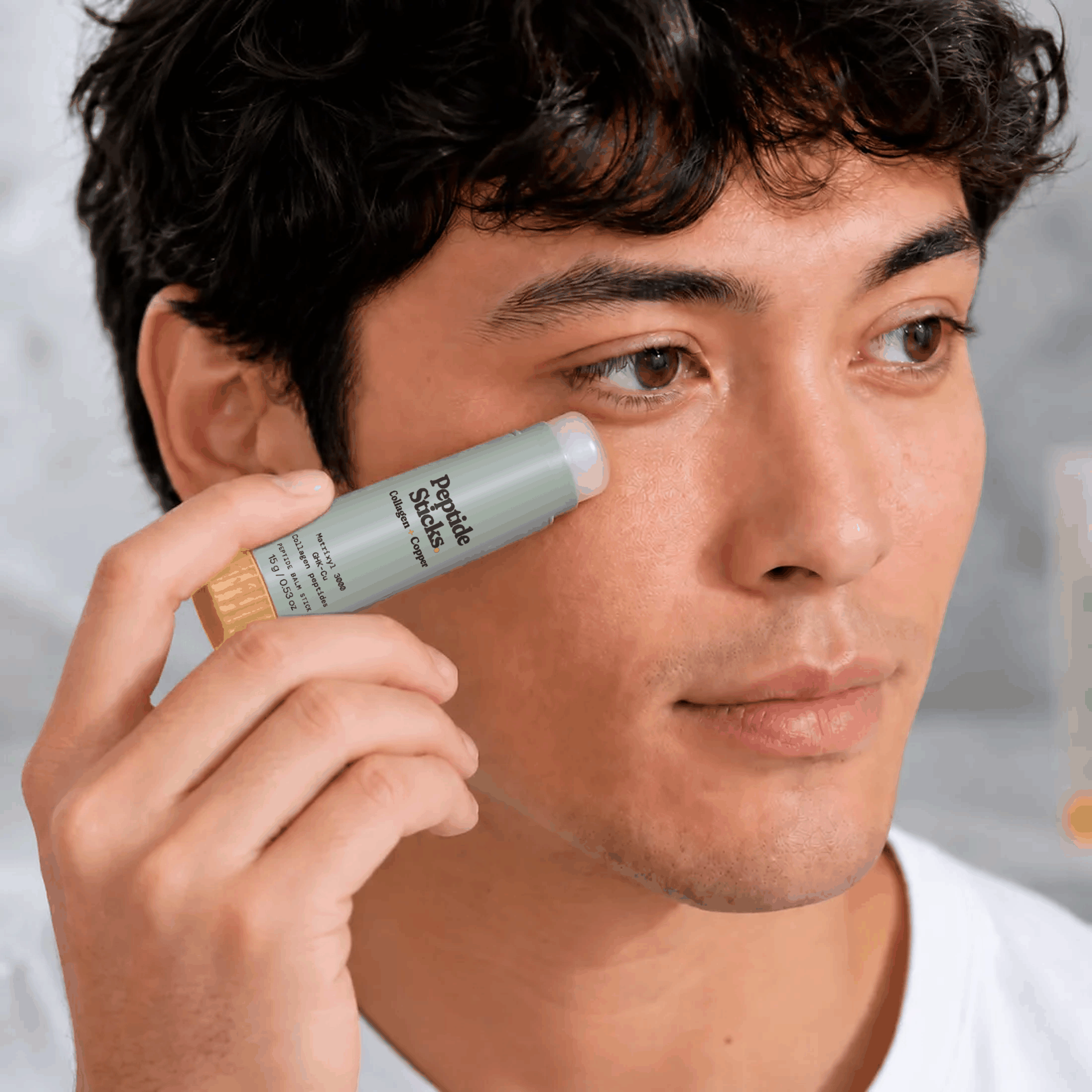 A clear peptide serum stick being applied along the jaw and neck.